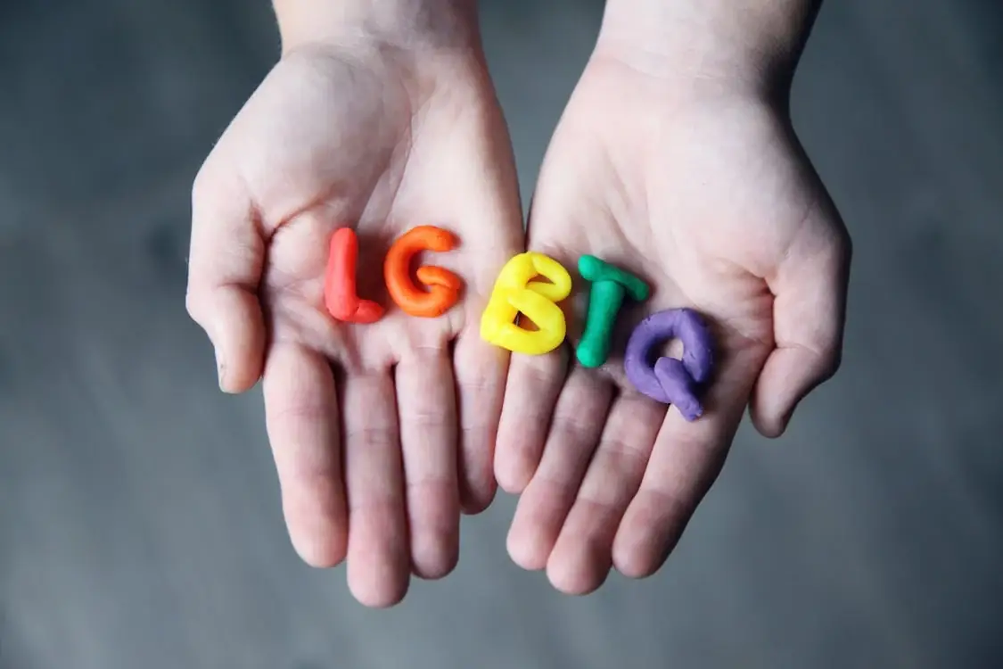 Hands holding LGBTQ letters