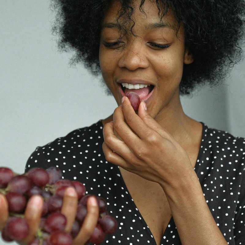 A woman eating grapes