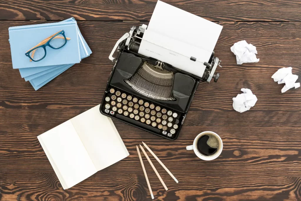 Old school typewriter on a table with papers and a cup of coffee