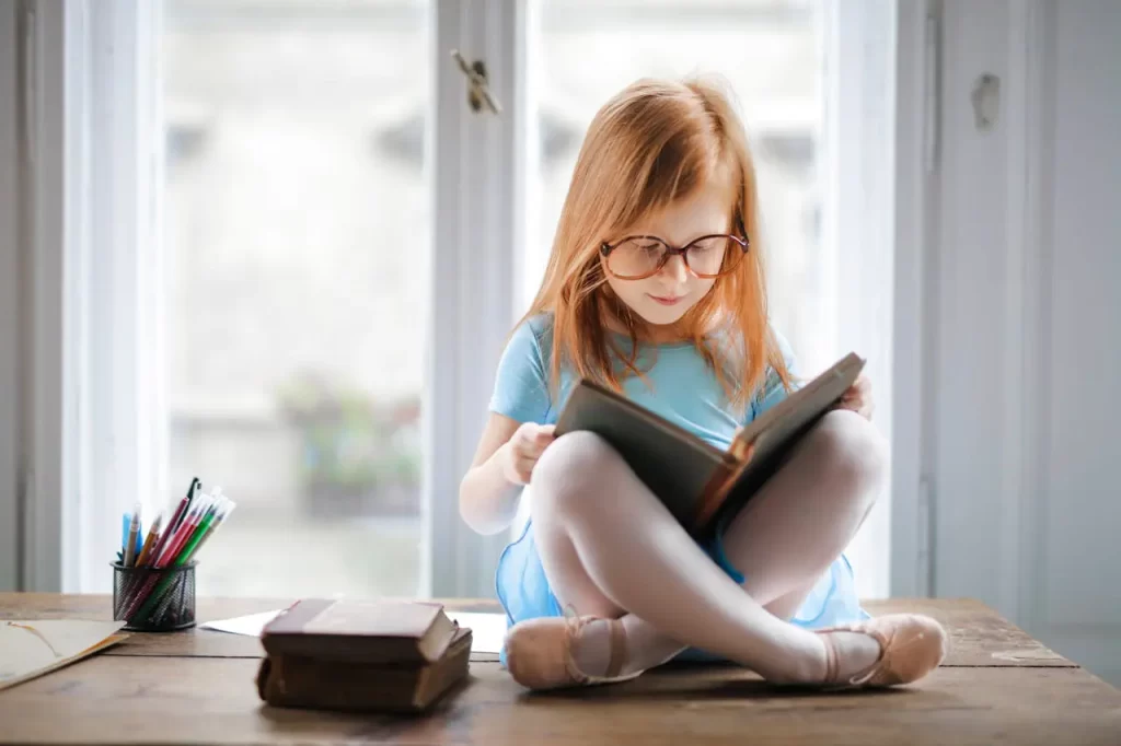 Young Girl Reading On Table